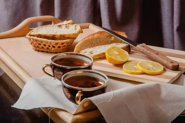 Due tazze di tè, limone e pane — Foto Stock