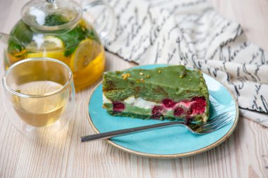  Ahşap masada, mavi tabakta fıstıklı kek.