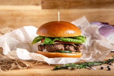 Peynirli domatesli hamburger, kızarmış yumurta ve salatalı ekmek.