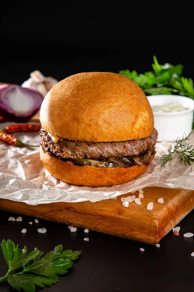 Hamburger, sığır pirzolası ve salatalıklı sandviç.