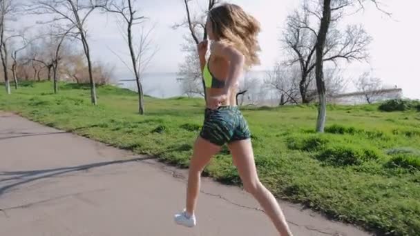 Женщина в спортивной одежде бегает — стоковое видео