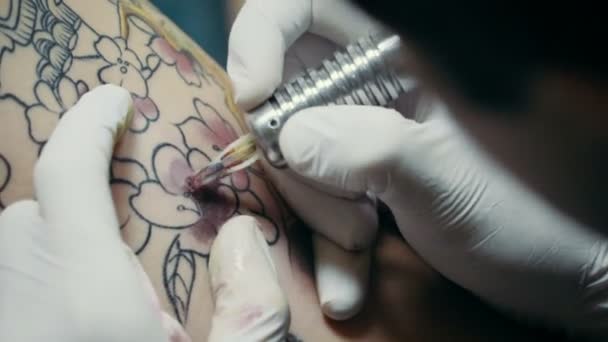 Татуировщик демонстрирует процесс — стоковое видео