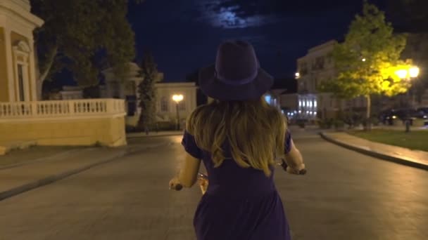 Mujer montando bicicleta vintage en la noche — Vídeo de stock