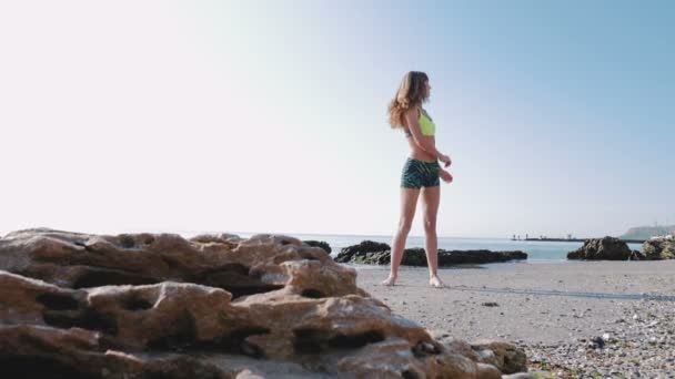 Mujer en ropa deportiva en la costa del mar — Vídeos de Stock