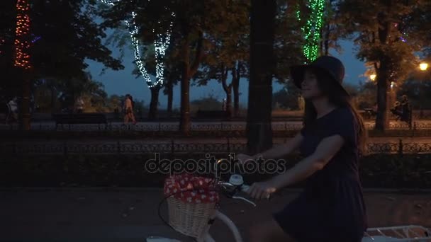 Woman riding vintage bike in night — Stock Video