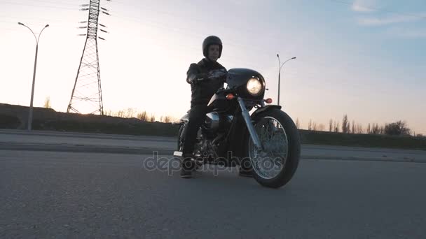 muž s motocyklu při západu slunce