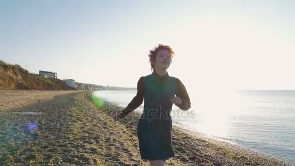 Frau läuft am Strand — Stockvideo