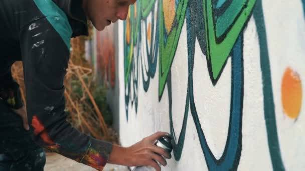 Человек рисует граффити на стене улицы — стоковое видео