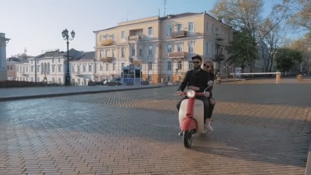 Pareja montando ciclomotor en centro de la ciudad — Vídeos de Stock