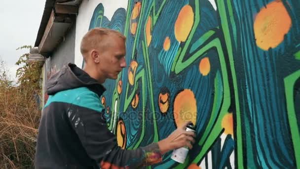 Человек рисует граффити на стене улицы — стоковое видео