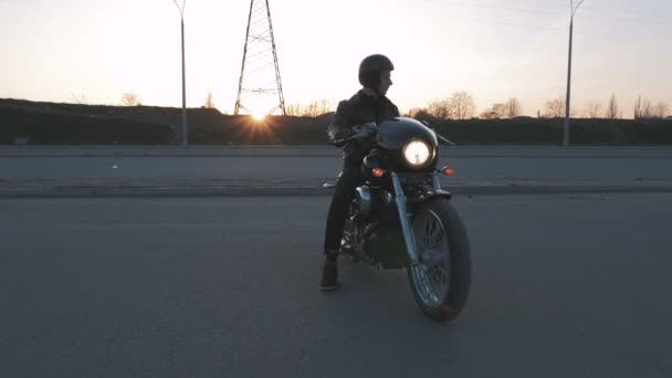 Людина з мотоциклом на заході сонця — стокове відео