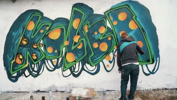 Man tekenen van graffiti op straat muur — Stockvideo