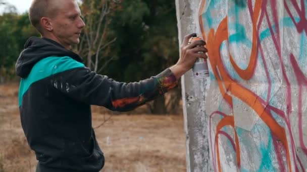 Чоловік малює графіті на вуличній стіні — стокове відео