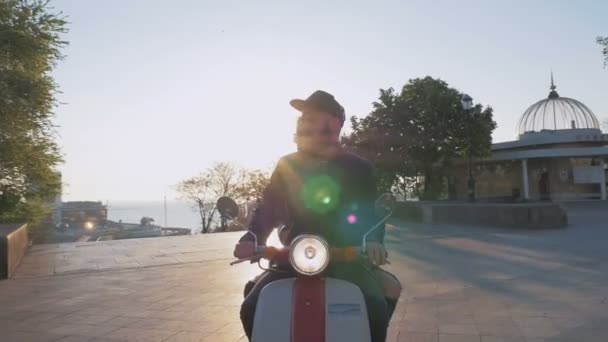 Pareja montando ciclomotor al atardecer — Vídeo de stock