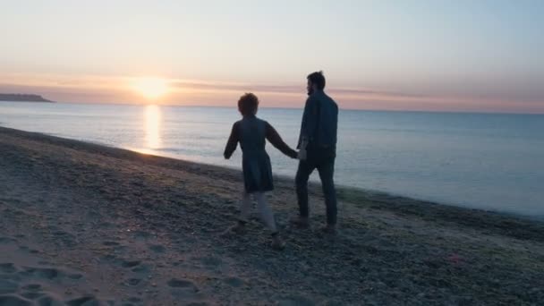 Любящая пара на пляже во время заката — стоковое видео
