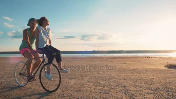 Pareja montar en bicicleta en la costa — Vídeos de Stock