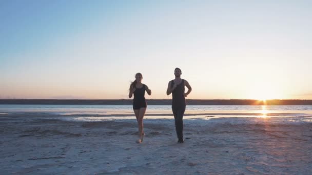 运动对夫妇在海滩上运行 — 图库视频影像