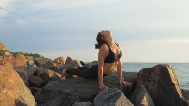 Mujer haciendo yoga sobre roca — Vídeo de stock