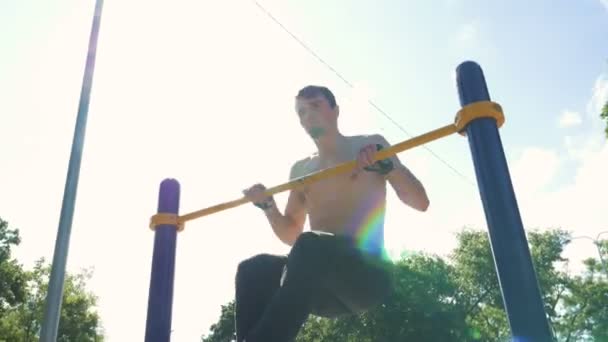 М'язистий чоловік тренується в парку — стокове відео