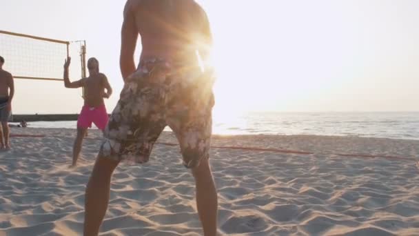 Los hombres juegan voleibol en la playa — Vídeo de stock