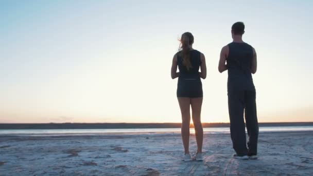 Couple faisant du yoga pendant le coucher du soleil — Video