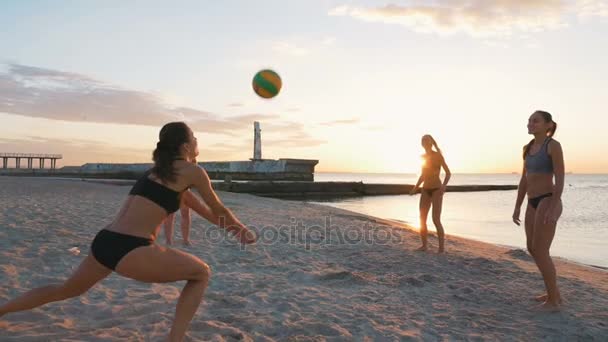 Las mujeres juegan voleibol al atardecer — Vídeo de stock