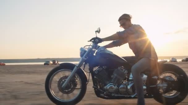 Hombre a caballo motocicleta en la costa — Vídeos de Stock