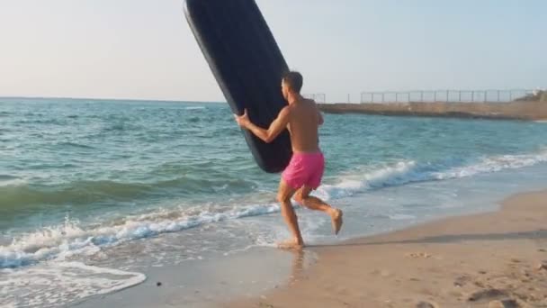 Человек бегает и прыгает в море — стоковое видео