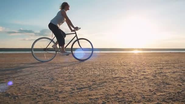 Csípő lány lovaglás kerékpár, tengerpart — Stock videók