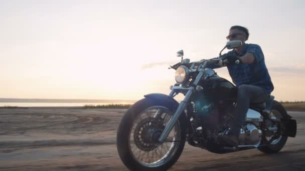 Hombre a caballo motocicleta en la costa — Vídeo de stock