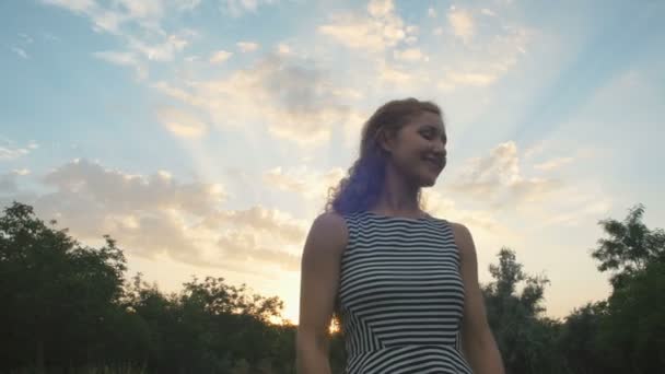 Žena v zeleném parku při západu slunce — Stock video