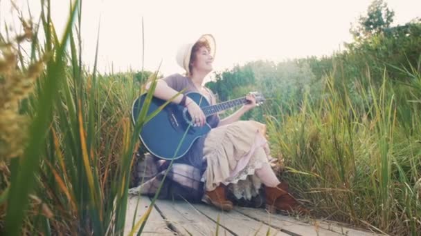 Mulher tocando guitarra na natureza — Vídeo de Stock