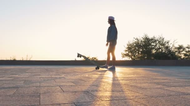 Hipster-Frau mit Longboard im Park — Stockvideo