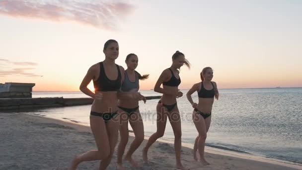 Mujeres corriendo en la playa al atardecer — Vídeos de Stock