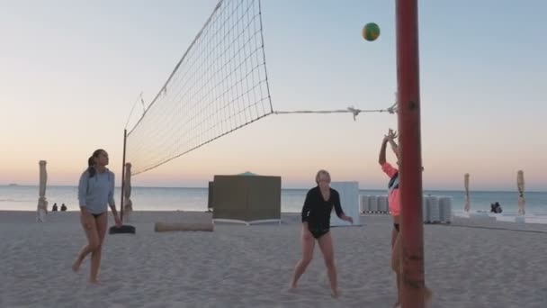 Жінки грають у волейбол на заході сонця — стокове відео