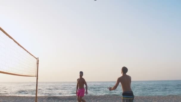 Чоловіки грають у волейбол на пляжі — стокове відео