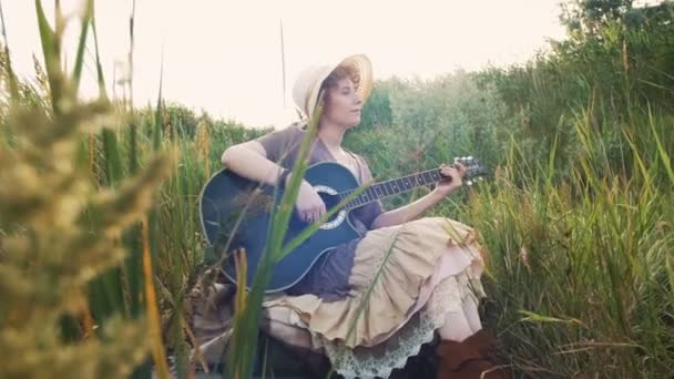 Woman playing guitar on nature — Stock Video