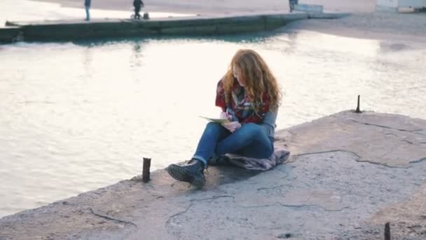 Женщина-хипстер пишет на блокноте — стоковое видео