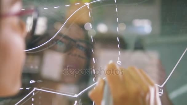 Женщина пишет знаки на стекле — стоковое видео