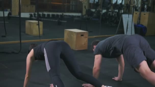 Пара делает упражнения в тренажерном зале — стоковое видео