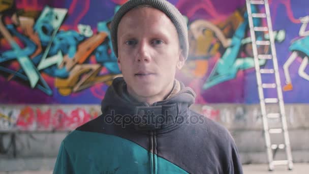 Hombre fumando cerca de la pared de graffiti — Vídeos de Stock