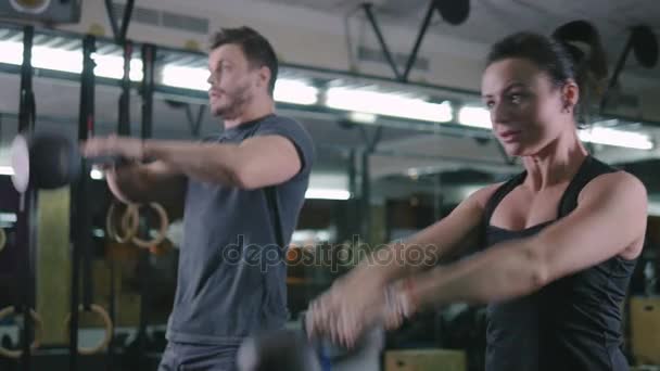 Пара делает упражнения в тренажерном зале — стоковое видео