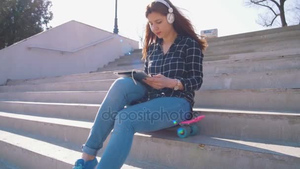 Девушка на лестнице слушает музыку — стоковое видео