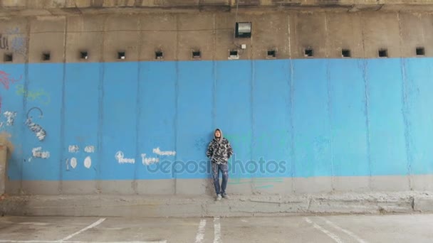 Человек на голубой металлической стене — стоковое видео