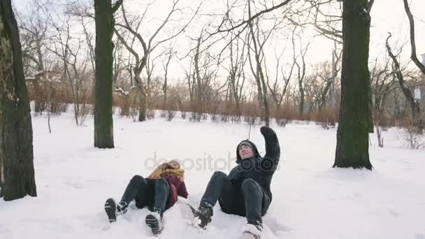 Pareja acostada en el suelo cubierto de nieve — Vídeos de Stock