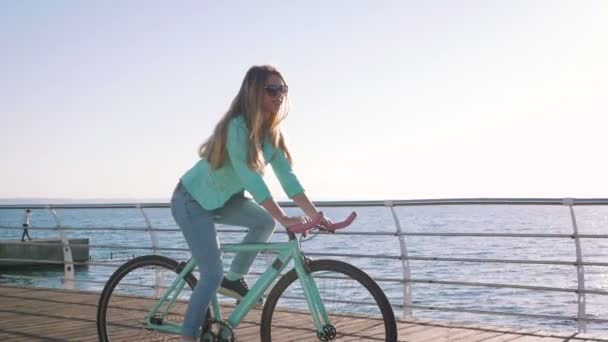 Femme à vélo sur le littoral — Video