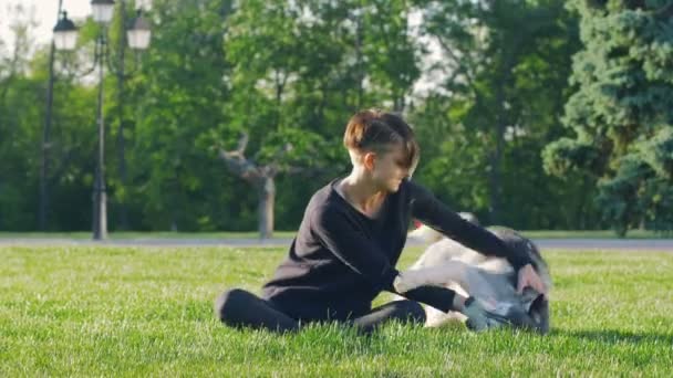 Хіпстерська жінка з хаскі в парку — стокове відео