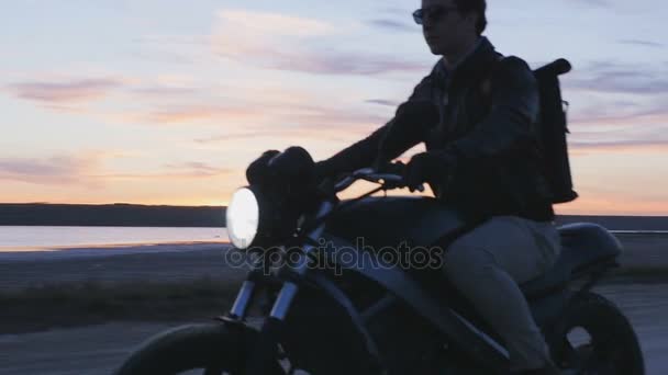 Человек на мотоцикле на закате — стоковое видео