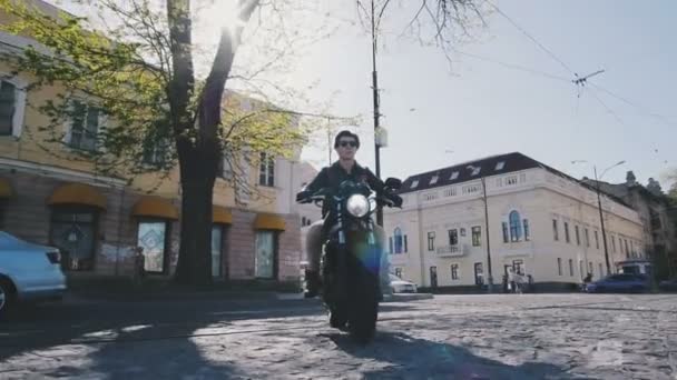 Чоловік їде на мотоциклі в місті — стокове відео