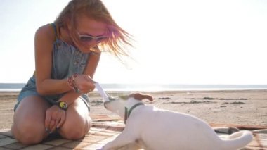 young woman playing with puppy